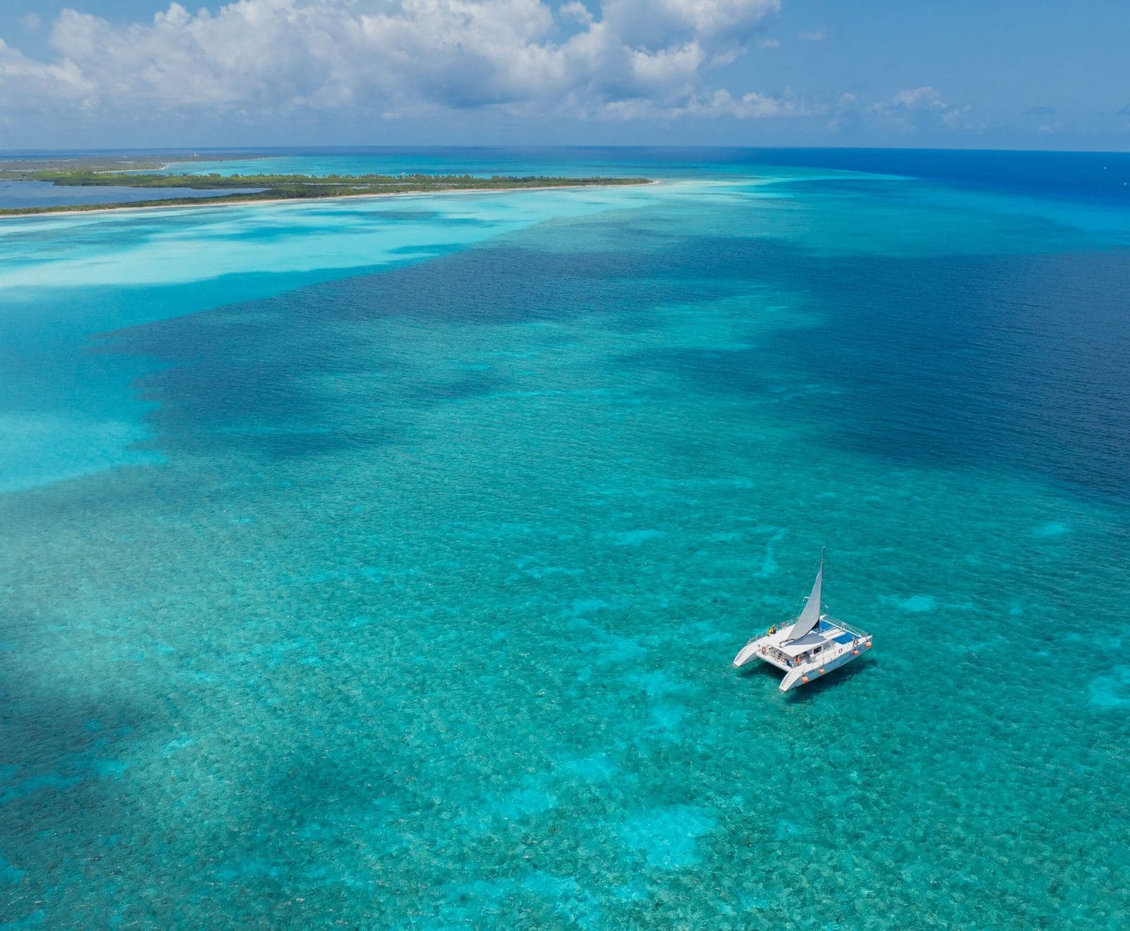 Aerial view of Cozumel's turquoise sea with a catamaran
